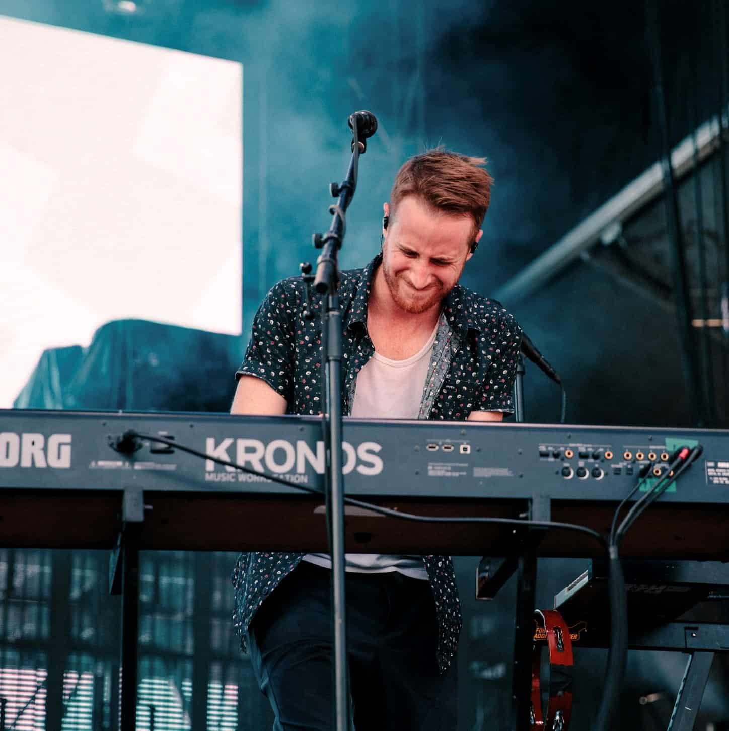Musician Wes Bailey standing behind his keyboard and playing enthusiastically